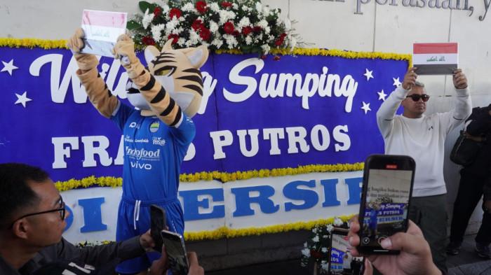 Wali Kota Bandung, Muhammad Farhan didampingi maskot Si Maung Bandung (Simba) memperkenalkan pemain anyar Persib Bandung, Frans Putros, yang namanya tertera pada karangan bunga bertuliskan Wilujeng Sumping di Persib, di bawah Jembatan Penyeberangan Orang (JPO), Jalan Asia Afrika, Kota Bandung, Jawa Barat, Rabu (16/7/2025).