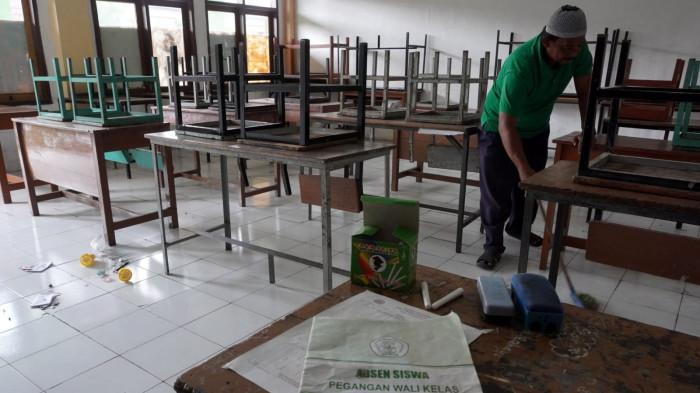 Petugas kebersihan menyapu salah satu ruang kelas yang sudah lama tidak diisi murid di Sekolah Menengah Kejuruan (SMK) Tamansiswa, Jalan Tamansiswa, Kota Bandung, Jawa Barat, Kamis (24/7/2025).