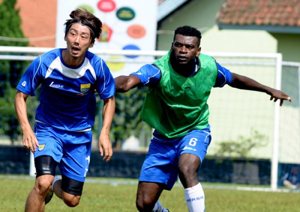 Pemain Persib Bandung Abanda Herman (kanan) berusaha menarik kaus Kenji Adachihara saat berebut bola umpan pada sesi latihan di Lapangan Pusdik Pom, Cimahi, Kamis (25/4). Pelatih Djadjang Nurjaman melakukan pembenahan  strategi penyerangan dan eksekusi bola-bola atas.
