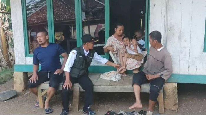 Umar (kanan) terlihat pasrah melihat kondisi anaknya tidak bisa berjalan hingga susah makan dan minum sejak lahir, Senin (3/6/2024).