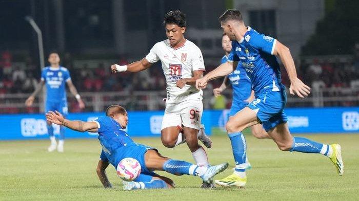 JATUHKAN DIRI - Bek Persib Bandung, Gustavo Franca, menjatuhkan diri untuk mengadang pergerakan pemain Malut United pada laga pekan ke-31 Liga 1 2024-2025 di Stadion Kie Raha, Ternate, Jumat (2/5/2025) malam. Persib kalah 0-1.