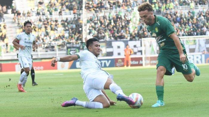 Bek Persib Bandung Putu Gede (putih) menyapu bola yang digiring gelandang Persebaya Surabaya Ze Valente pada laga di Stadion Gelora Bung Tomo, Sabtu (7/10/2023). Persib menang 3-2.