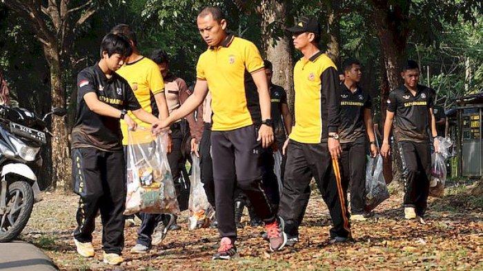 Personel Polres Purwakarta melakukan bersih-bersih sampah di objek wisata Waduk Jatiluhur, Kamis (13/7/2023)
