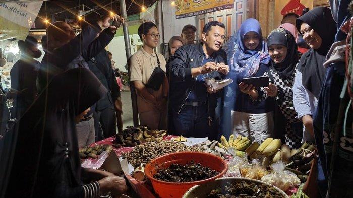 Penjabat Bupati Majalengka, Dedi Supandi (kedua dari kiri), membeli tutut langganannya saat menikmati kuliner malam di Pasar Mambo di Kelurahan Majalengka Wetan, Kecamatan/Kabupaten Majalengka, Sabtu (27/1/2024) malam.