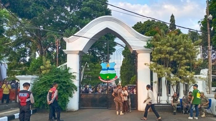 Gerbang Timur Pendopo Garut, Jawa Barat, Jumat (18/7/2025). Sejumlah aparat kepolisian dan Satpol PP berjaga usai insiden sejumlah warga tewas usai mengantre makanan di Pesta Rakyat yang merupakan rangkaian pernikahan Maula Akbar, putra dari Gubernur Jabar Dedi Mulyadi dan Wakil Bupati Garut Putri Karlina.
