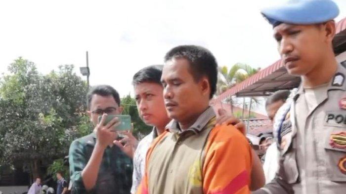 Polisi saat menggiring pelatih renang bernama Jaimas Simaremare di Polres Asahan, Selasa (6/8/2024). Dia ditangkap karena menendang guru renang wanita hingga pingsan karena rebutan area latihan renang.