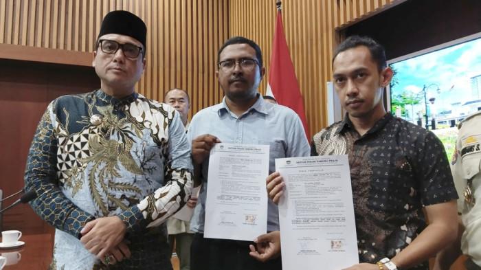 DISANKSI PEMKOT BANDUNG - Perwakilan Komunitas lari menunjukkan surat kesediaan disanksi Pemkot Bandung, Kamis (24/7/2025). Dua komunitas yang terlibat dalam bagi-bagi bir di acara Pocari Sweat Run 2025 dipanggil ke Pemkot Bandung untuk diberikan sanksi. 
 