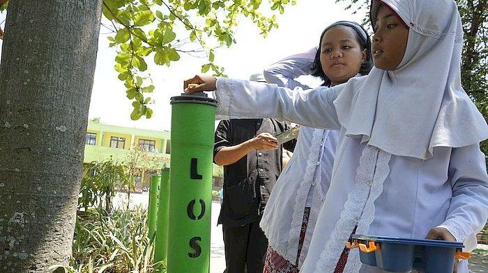 Para murid SDN 077 Sejahtera, Kota Bandung memasukkan sisa makanan ke dalam Loseda (Lodong Sesa Dahar) untuk dijadikan kompos, Kamis (19/10/2023)