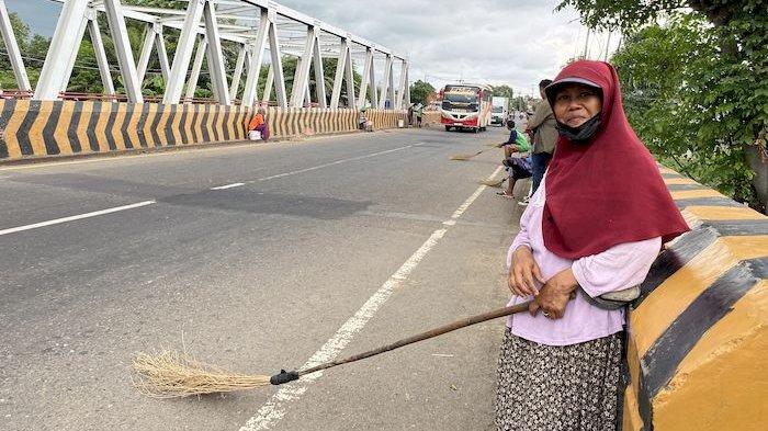 SEPI PENYAPU KOIN - Maskirah, penyapu koin di Jembatan Sewo perbatasan Subang-Indramayu di Jalur Pantura, Senin (24/3/2025).