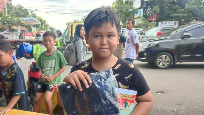 Muhammad Rendar Fadila, murid kelas 4 di SD Leuwianyar mendapatkan buku dan kaus dari Jokowi saat berada di Terminal Leuwipanjang, Bandung, Sabtu (3/2/2024).