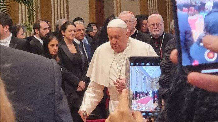 Paus Fransiskus berjalan di depan para diplomat sebelum menyampaikan pidato perdamaian di Hall of Benedict Vatikan, Senin (8/1/2024)