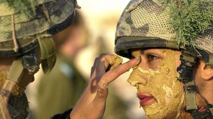Ilustrasi - Foto yang dirilis oleh Angkatan Bersenjata Israel memperlihatkan dua prajurit perempuan Israel sedang mengaplikasikan cata kamuflasi ke wajah.