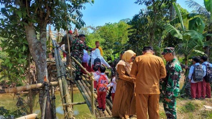 Pelajar dan guru di Kampung Cigirang, Desa Neglasari, Kecamatan Lengkong, Kabupaten Sukabumi, kini melalui jembatan dari bambu setelah sebelumnya viral bergelantungan di jembatan rusak untuk pergi ke sekolah.