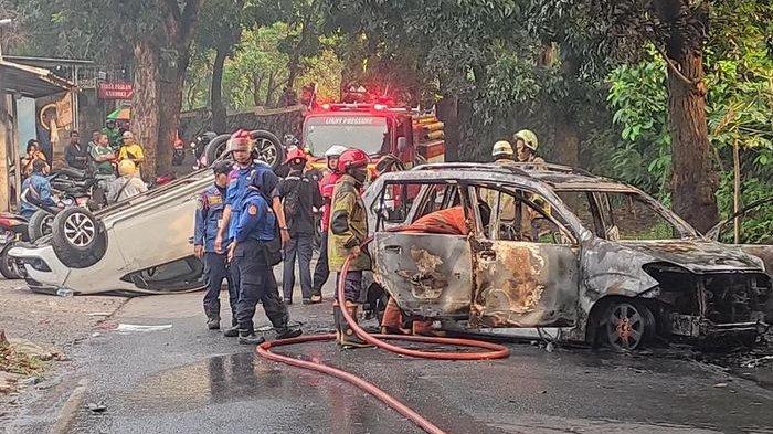 PADAMKAN API - Petugas pemadam kebakaran saat memadamkan api yang membakar mobil polisi yang dirusak massa saat menangkap seorang pria pelaku penganiayaan dan kepemilikan senjata api berinsial TS di kawasan Harjamukti, Depok.