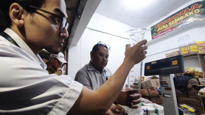 MENGUKUR TAKARAN - Petugas saat mengukur takaran MinyaKita di Pasar Kosambi, Kota Bandung, Senin (10/3/2025),