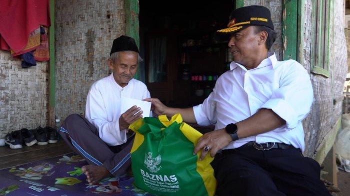 Pj Bupati Herman Suryatman saat memberikan santunan pada salah satu warga 