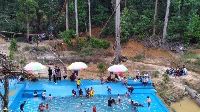 Potret pengunjung Lembah Pelangi Batam menikmati kolam renang yang airnya bersumber dari mata air, Jumat (8/7/2022).