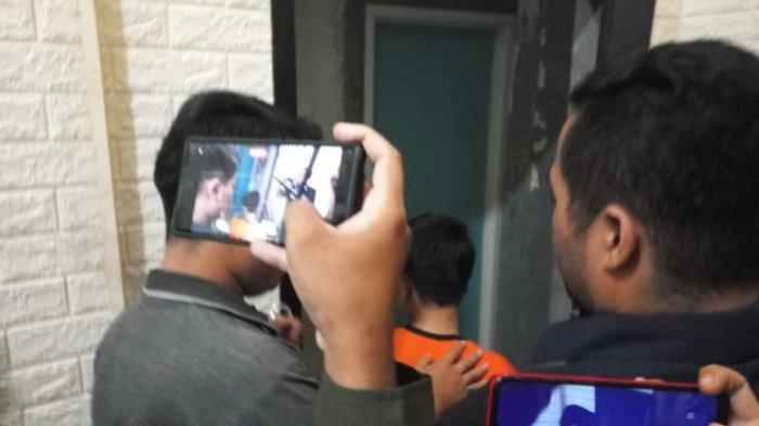 Rahmat (baju orange), pelaku pembunuhan terhadap ibu kandungnya, saat diamankan polisi dan digiring ke tahanan Satreskrim Polres Sukabumi, Selasa (14/5/2024) sore.