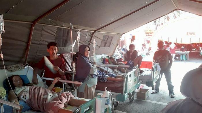 Ratusan pasien Rumah Sakit Umum Daerah Sumedang yang ditempatkan di tenda darurat  merasa kepanasan sampai-sampai keluarga pasien pun mencoba mengipasi keluarganya, Senin (1/1/2024).
