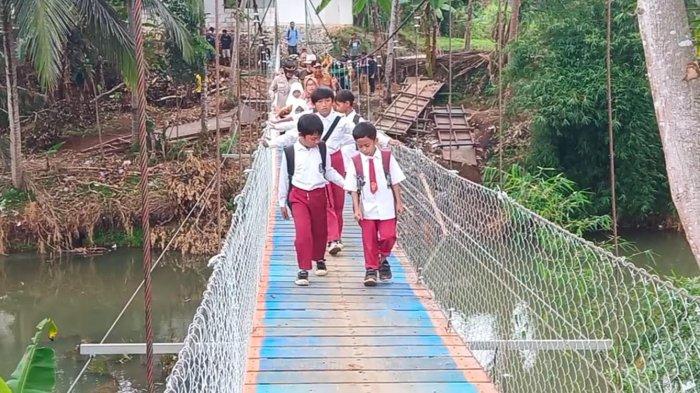 Sejumlah murid SD menyeberang sungai lewat jembatan yang baru dibangun tanpa anggaran Pemkab Sukabumi di Desa Neglasari, Kecamatan Lengkong, Kabupaten Sukabumi, Jawa Barat, Selasa (10/9/2024).