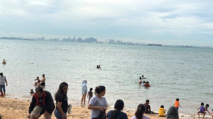 WISATA PANTAI DI BATAM - Potret pengunjung Pantai Tanjung Pinggir di Kecamatan Sekupang, Kota Batam, Provinsi Kepulauan Riau (Kepri), Sabtu (13/4). Tampak deretan gedung Negara Singapura.