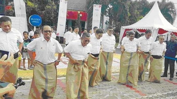 CEO Telkom Group Alex J. Sinaga (ke empat dari kiri), Direktur Utama Telkomsel Ririek Ardiansyah (paling kiri), Asisten Deputi Layanan Hukum Kementerian BUMN Dwi Ary Purnomo (ketiga kiri) membuka rangkaian lomba HUT RI ke 71 dengan Balap Karung di lapangan Telkom Regional V, Surabaya (17/8). Upacara Peringatan HUT RI ke 71 yang ditutup dengan lomba-lomba khas 17an menjadi acara puncak dari rangkaian program BUMN Hadir untuk Negeri.