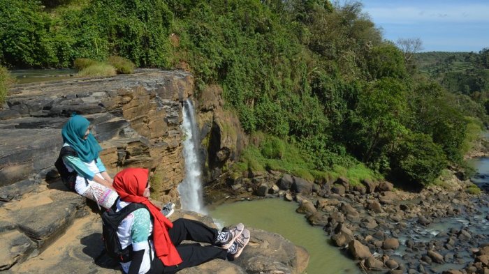 Pengunjung menikmati pemandangan dari puncak Curug Awang di Geopark Ciletuh, Kabupaten Sukabumi, Jawa Barat.