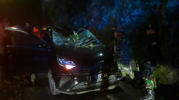 CADAS PANGERAN - Sebuah mobil rusak tertimpa pohon tumbang di Jalan Cadas Pangeran, Sumedang, tumbang, Minggu (30/3/2025) malam.