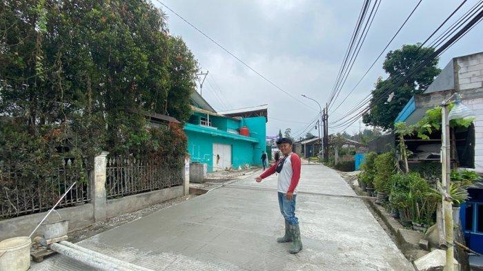 Pekerja menunjukkan jalan yang baru dicor yang diterobos pemotor di Kampung Panyairan Jompo, RT 3/2, Desa Cigugur Girang, Kecamatan Parongpong, Kabupaten Bandung Barat (KBB), Selasa (2/7/2024) pagi.