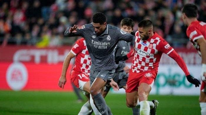 Pemain Real Madrid, Jude Bellingham (abu-abu) menerobos pertahanan Girona di lanjutan Liga Spanyol di Stadion Municipal Montilivi, Girona, Sabtu 7 Desember 2024.