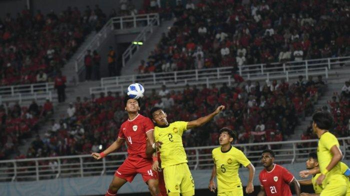 Pemain Timnas Indonesia U-19 Kadek Arel berebut bola dengan bek Malaysia Mohammad Rizwan di semifinal Piala AFF U-19 2024 di Stadion Gelora Bung Tomo, Sabtu (27/7/2024).