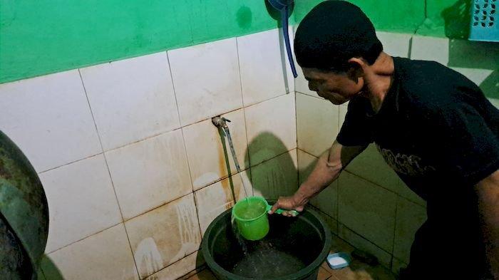 Warga Kampung Gunungbatu RT 02/04, Desa/Kecamatan Kebonpedes, Kabupaten Sukabumi, Ade Deni (63) memperlihatkan air sumur  berwarna kekuningan dan bau. Krisis air  bersih di sana sudah berlangsung selama 13 tahun lebih.