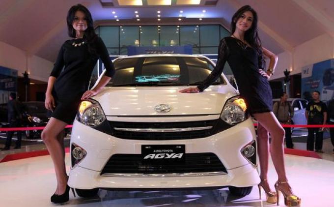 TOYOTA AGYA - Dua orang model berpose di samping mobil Astra Toyota Agya saat acara peluncuran tersebut di Graha Tirta Siliwangi, Jalan Lombok, Kota Bandung, Jumat (27/9). Mobil yang dihadirkan sebagai salah satu upaya merespon kebijakan pemerintah berupa mobil murah sekaligus melengkapi product line-up Toyota di segmen compact car dengan 1.000 cc tersebut hadir dalam tiga pilihan tipe yang dijual dari mulai harga Rp 101.400.000 hingga Rp 122.250.000 per unit.