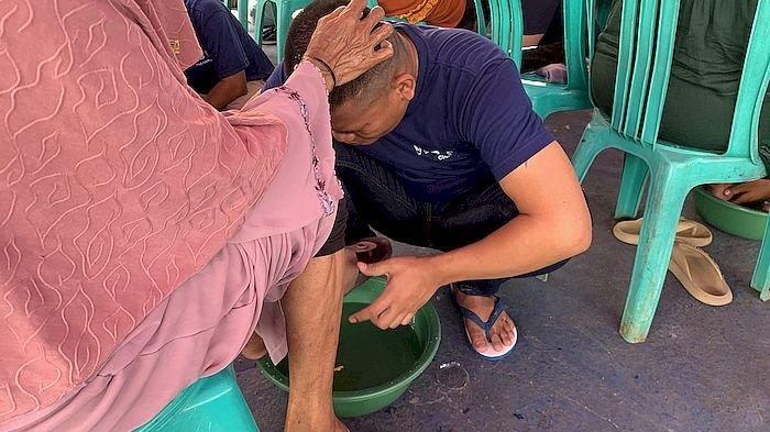 Dedi Suhendi, napi lapas Cianjur saat membasuh kaki sang ibu di Lapas II B, Cianjur, Jumat (22/12/2023).