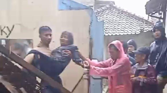 Bripka Agus Suryadi menggendong nenek di tengah hujan deras