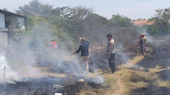 Petugas gabungan saat berupaya memadamkan api yang membakar areal lapangan di belakang SMPN 1 Kandanghaur Indramayu, Senin (11/9/2023).