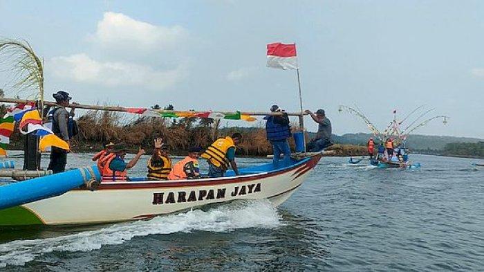 Perahu nelayan berhiaskan bendera dan pernak-pernik pawai di aliran Sungai Citanduy, Kalipucang, Senin (23/10/2023). Kegiatan ini menyambut milangkala ke-11 Kabupaten Pangandaran.