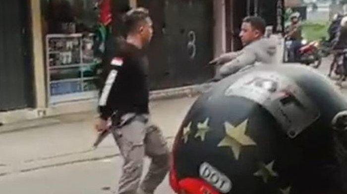 Seorang pria memegang benda diduga senjata api saat cekcok dengan orang lain di jalanan di Rancamanyar, Kabupaten Bandung, Sabtu (27/4/2024) sore.