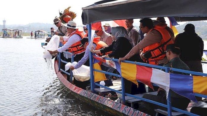 Gubernur Jawa Barat Ridwan Kamil menabur benih ikan saat peresmian kawasan wisata Situ Bagendit yang terletak di Kabupaten Garut, Senin (21/8/2023).