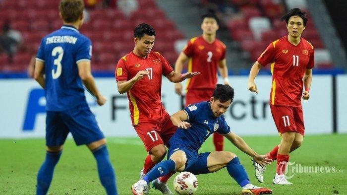 Pemain Timnas Vietnam Vu Van Thanh (tengah kiri) berebut bola dengan pemain Timnas Thailand Supachok Sarachat pada pertandingan leg pertama semifinal sepak bola AFF Suzuki Cup 2020 antara Vietnam dan Thailand di National Stadium di Singapura pada 23 Desember 2021.