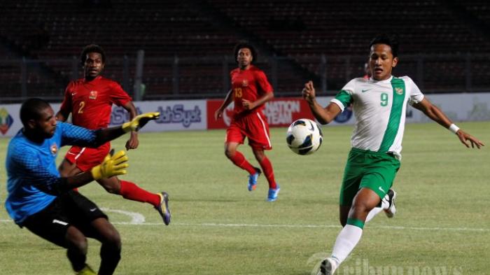 Yandi Sofyan Munawar (kanan) saat membela timnas Indonesia U-23 berusaha melewati penjaga gawang Papua Niugini, Wilbert Benjamin pada pertandingan MNC Cup 2013 di Stadion Utama Gelora Bung Karno (SUGBK), Senayan, Jakarta Pusat, Jumat (22/11/2013) malam. Indonesia menang telak 6-0.