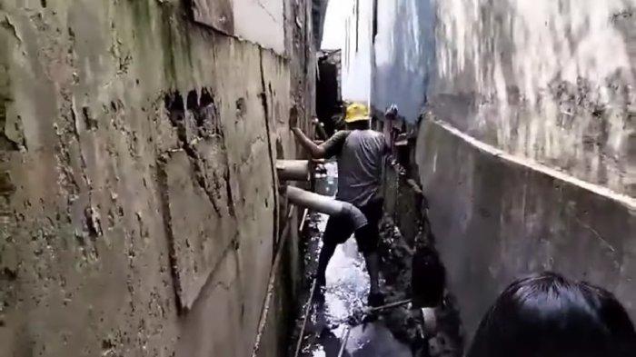 Akses comberan menuju rumah Ngadenin yang terkurung bangunan Hotel di Jatiwaringin, Kecamatan Pondok Gede, Kota Bekasi.