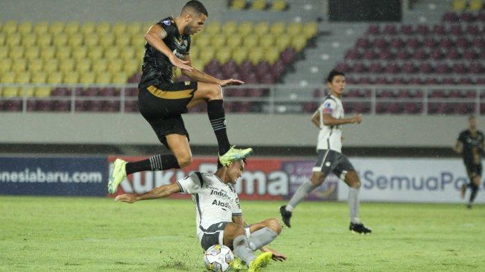 Bek Persib Bandung, Zalnando (bawah) menghalau bola dengan kakinya  