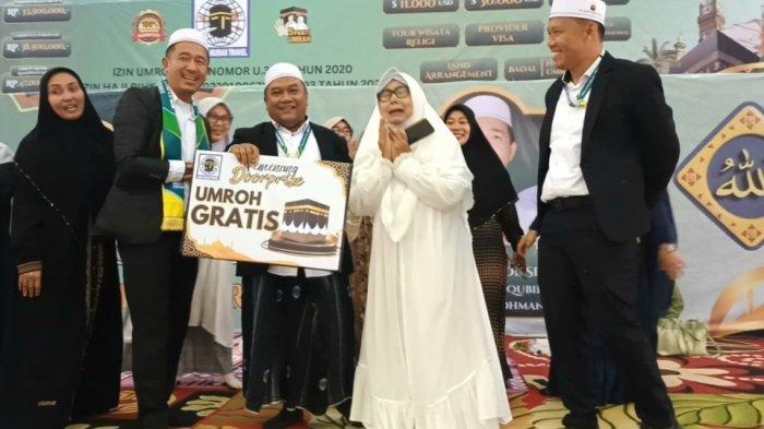 Direktur PT Adam Hijrah Travel, H. Adam Damhudi (tengah) saat memberikan hadiah umrah gratis bagi Nani Rahmawati di Asrama Haji Jakarta, Sabtu (19/10/2024).