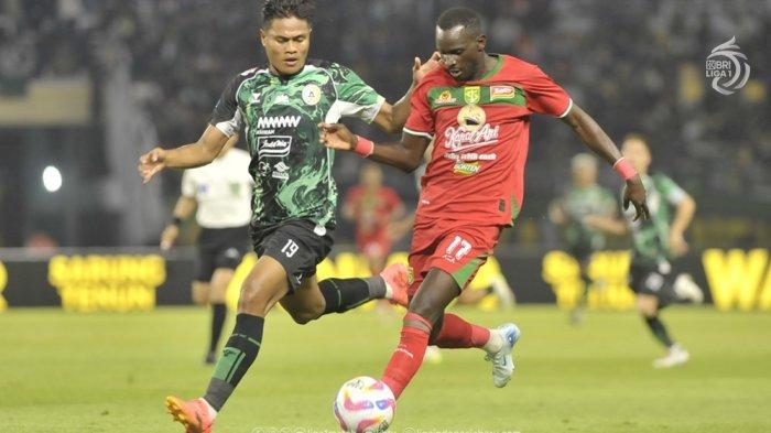 Penyerang Persebaya Surabaya, Flavio Silva dikawal ketat bek PSS Sleman, Fachruddin Aryanto di Liga 1.