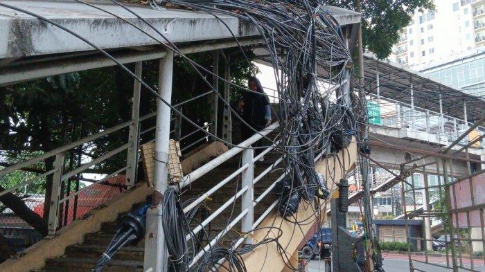 Kondisi kabel udara semrawut pada JPO Otista di Bidara Cina, Jatinegara, Jakarta Timur, Sabtu (14/6/2025).