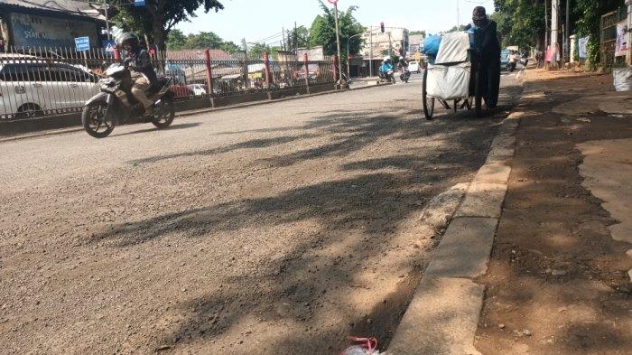 Kondisi Jalan Raya Bogor di kawasan Hek yang rusak terdampak banjir luapan Kali Baru, Kramat Jati, Jakarta Timur, Jumat (30/6/2023).