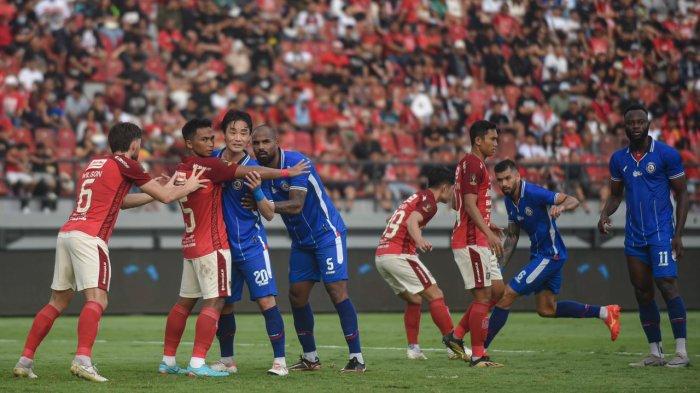 Pemain Bali United dan Arema FC berduel di lapangan.