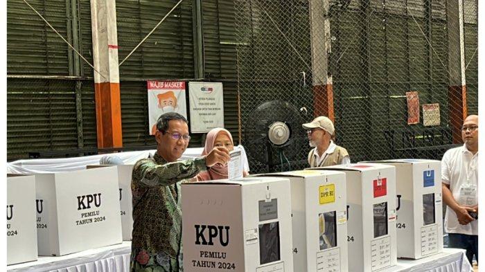 Pj Gubernur DKI Heru Budi Hartono bersama sang istri, Mirdiyanti saat mencoblos di TPS 055, Duren Sawit, Jakarta Timur, Rabu (14/2/2024).