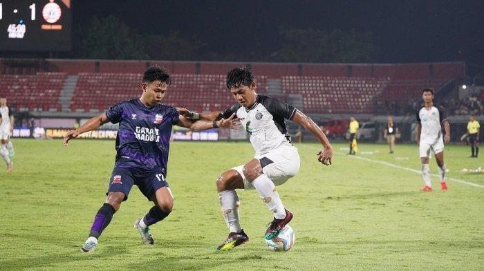 Bek sayap Persija Jakarta, Firza Andika berusaha melindungi bola dari rebutan pemain Madura United, Irfan.